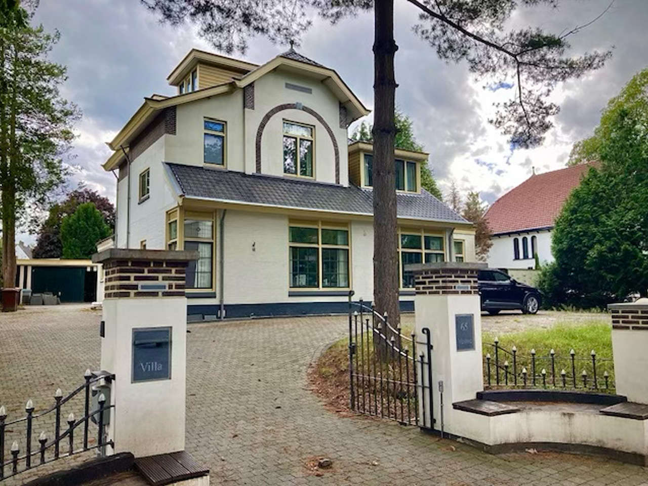 The Synvestor office at Burg. Grothestraat 65 in Soest: a white villa with dormer windows, seen from the entrance gate.